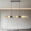 Warner linear marble suspension light in brass over a table