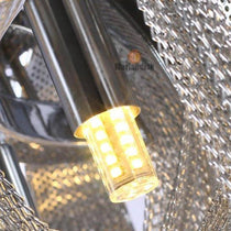 The Cadena chain tassel chandelier by Morsale.com lit in a living room, stainless steel ring with aluminum tassels.
