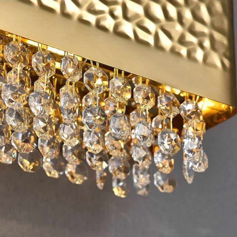 The Bern crystal wall sconce by Morsale.com illuminated in a hallway, gold frame with clear K9 crystal.