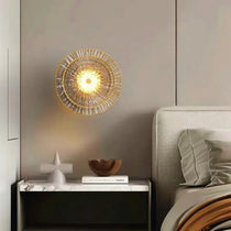 Clara round brass wall sconce mounted in a hallway