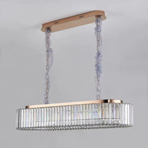 Gio crystal dining chandelier illuminated above a long dining table