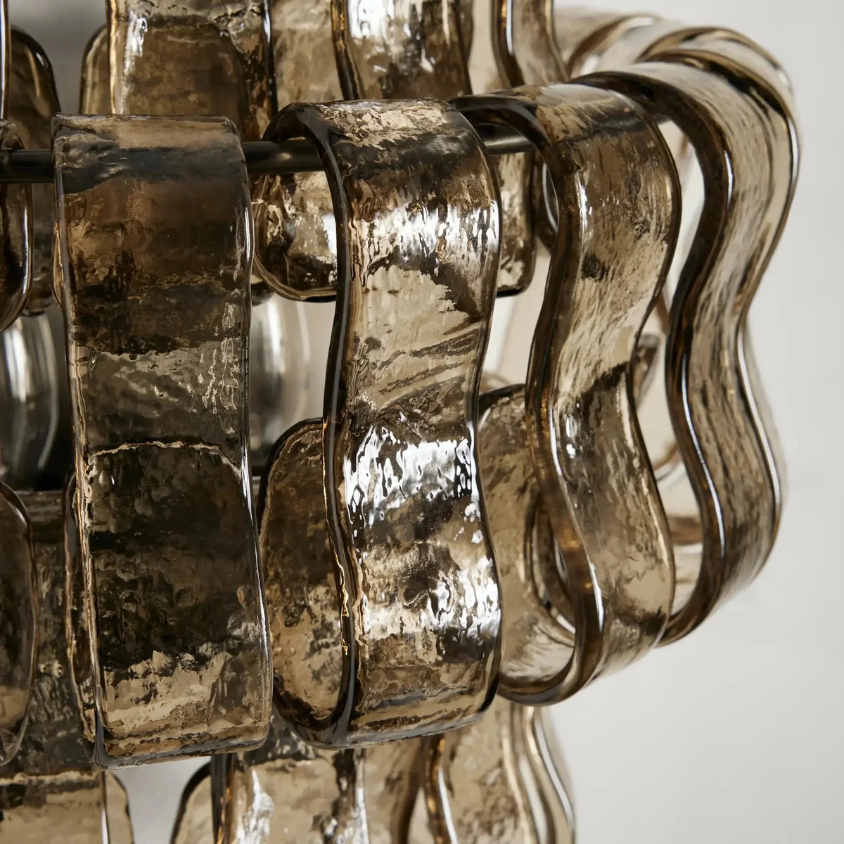Riviera smoke glass wall sconce mounted on a wall