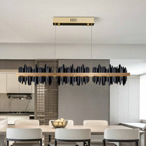 Rivaro modern linear chandelier in black and gold over a dining table