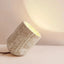 Modern travertine table lamp on a console with a warm glow
