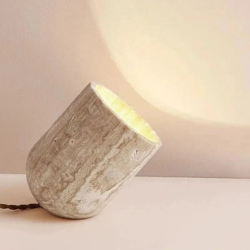 Modern travertine table lamp on a console with a warm glow Main image