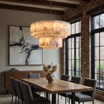 Oakley layered marble chandelier illuminated over a dining table