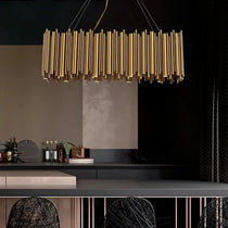 The Vigo gold rectangular chandelier from Morsale.com casting warm light over a dining setting, polished gold steel frame.