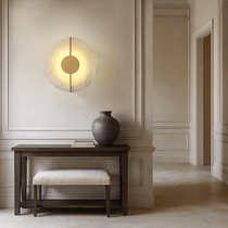 Altura marble disc sconce illuminated with a warm glow