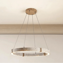 Danford travertine chandelier illuminated over a dining table
