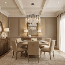 The Cadena tassel ring chandelier from Morsale.com above a dining table, fluid metal tassel curtain glowing warm.