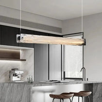 Costa glass pendant casting focused light over a bar