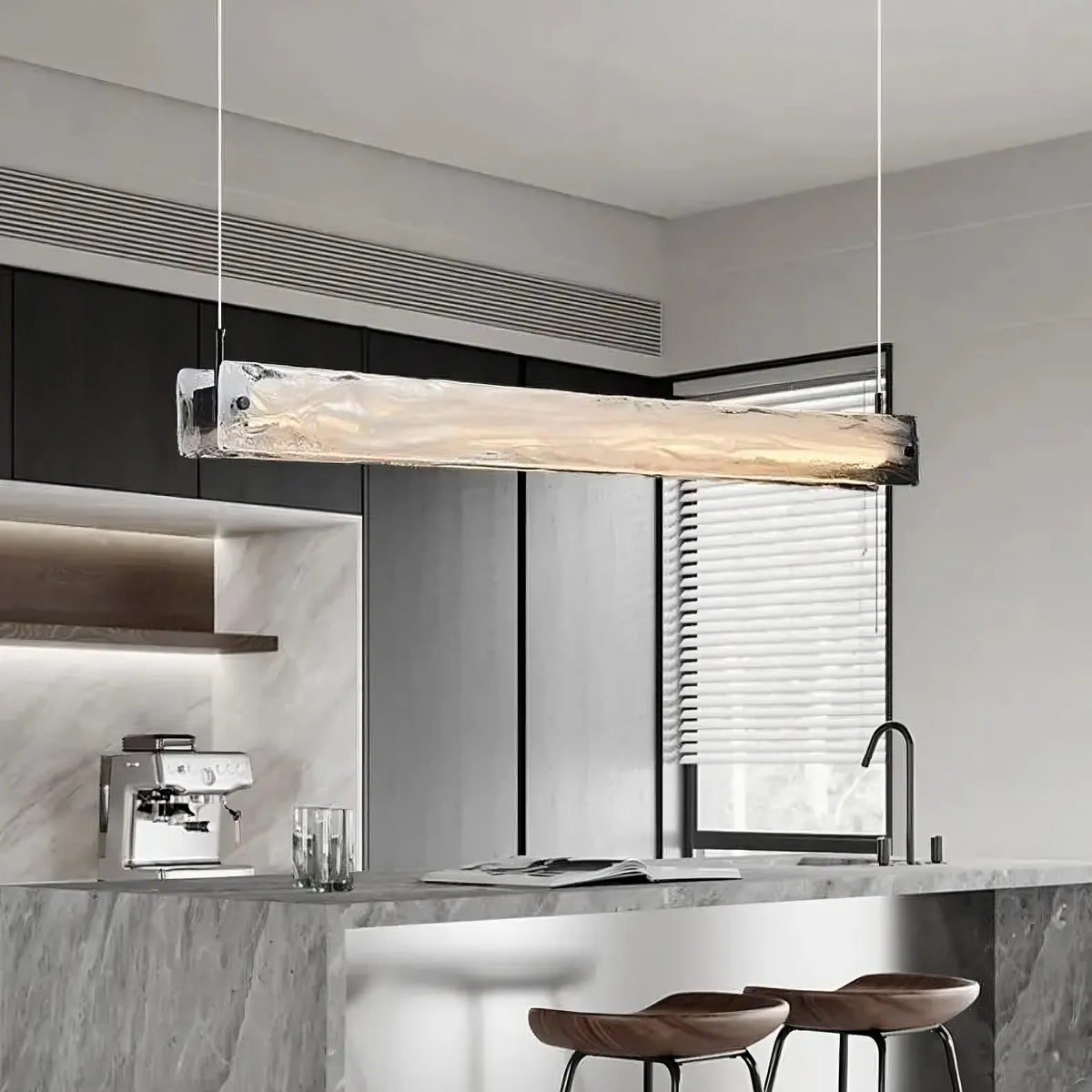 Costa glass pendant casting focused light over a bar